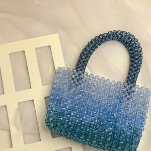 Detail of handmade beaded handbag with gradient blue acrylic beads and woven texture