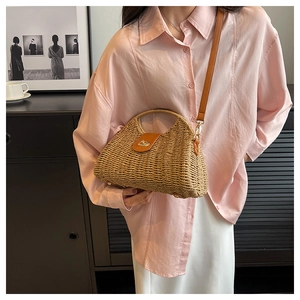 Detailaufnahme der Stroh-Handtasche mit brauner Lederklappe und goldenem Drehverschluss