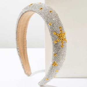 Detail of sponge headband with silver rhinestones and gold star crystals on a white stand