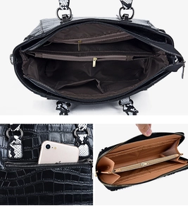 Detail view of large capacity black croc-embossed tote bag with snake print handles