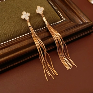 Macro view of gold four-leaf clover stud earrings with cascading long snake chain tassels