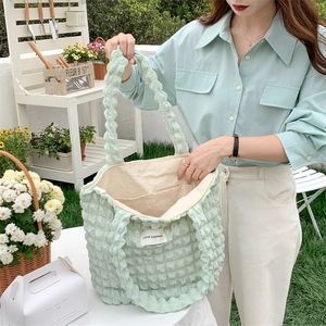 Detail of light green bubble texture tote bag showing interior pocket and large capacity