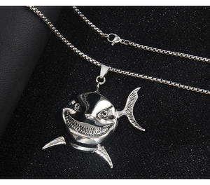Macro shot of a silver shark head pendant with evil smile on a box chain necklace