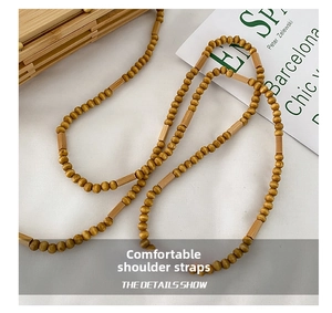 Detail of handcrafted wooden beaded shoulder strap on a natural straw beach bag