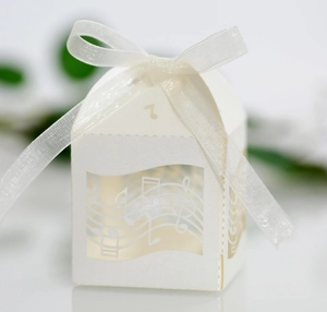 Détail de motifs musicaux découpés au laser sur boîte cadeau ivoire avec un nœud en ruban