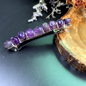 Detailed close-up of handmade bohemian hair clip with purple natural amethyst stones