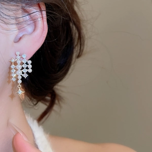 Close-up of starburst pearl earring with cubic zirconia on model's ear