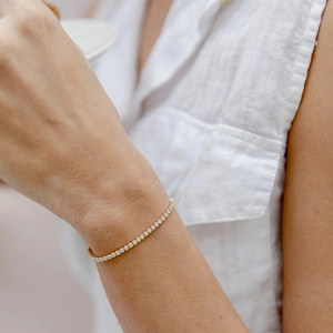 Close-up of elegant gold plated 925 silver tennis bracelet with cubic zirconia on wrist