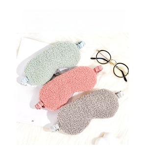 Flat lay of soft plush sleep masks in mint, pink, and grey with silky elastic straps