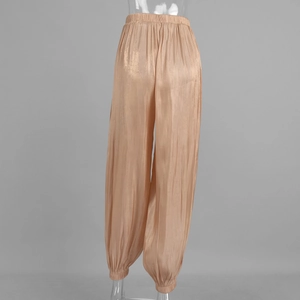 Back view of champagne gold satin harem pants with glossy finish and elastic waistband