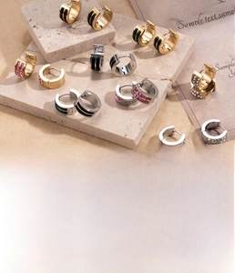 Close-up of titanium steel hoop earrings with double-row zircon pavé in gold and silver