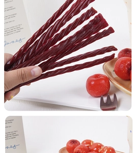 Macro shot of dark red twisted hawthorn candy strips with a glossy natural texture