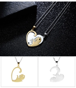 Detail of interlocking black and white cat pendants forming a heart in gold and silver