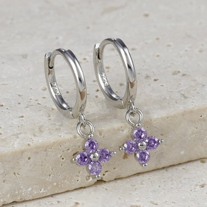 Macro detail of S925 sterling silver hoop earrings with purple zircon flower petals