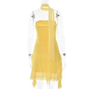 Détail d'une mini-robe jaune en dentelle avec ourlet à volants et écharpe assortie sur buste