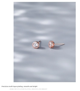 Detailed macro view of rose gold round stud earrings with hollow heart side patterns