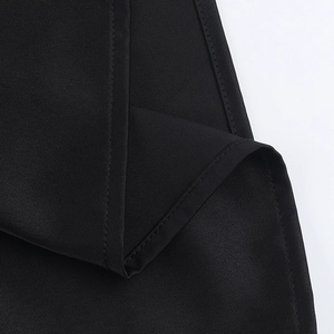 Close-up of high-quality black woven fabric texture and stitching for halter neck dress