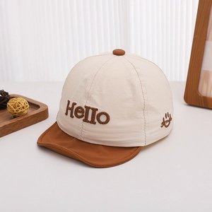 Détail de la casquette bébé beige avec broderie Hello et visière courte marron souple