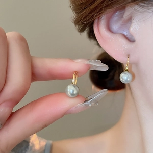 Detail of grey pearl earrings with 18K gold hooks shown on model for elegant style