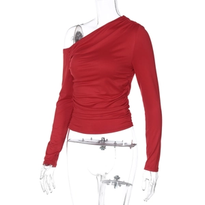 Détail du haut rouge à une épaule avec texture froncée et tissu élastique brillant
