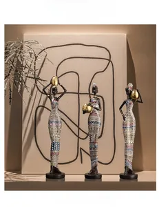Artistic close-up of three African tribal women resin figurines in colorful geometric dresses