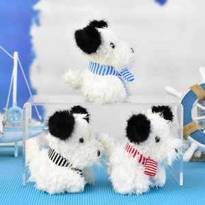 Three cute Westie plush dog pendants with blue, red and black striped scarves on display.