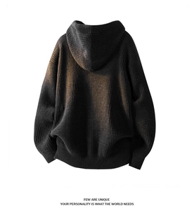 Detail view of oversized dark grey thick knit hoodie showing ribbed hem and back texture