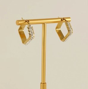 Detail of 18K gold plated earrings with Greek key pattern and sparkling zircons
