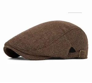 Dettaglio berretto piatto in tweed spinato kaki con fibbia in metallo regolabile