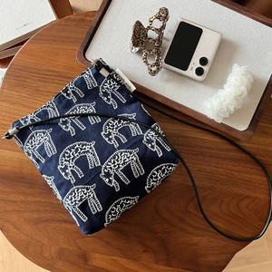 Detail of navy canvas crossbody bag with white sheep embroidery and a minimalist design