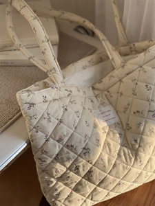 Gros plan du sac cabas matelassé en velours côtelé avec motif floral et texture coton doux