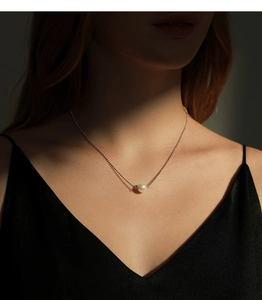 Elegant s925 silver necklace with a single white pearl pendant on a model's collarbone