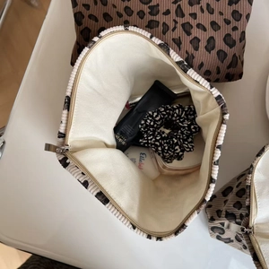 Vue de dessus d'une trousse à maquillage léopard en velours côtelé avec rangement