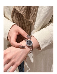 Detail of silver rhinestone watch with black dial worn on a stylish wrist