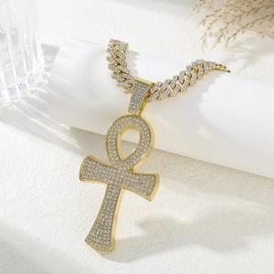 Détail du collier chaîne cubaine dorée avec pendentif croix ankh et strass brillants
