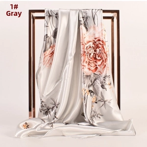 Dettaglio del drappeggio della sciarpa in raso grigio argento con motivi floreali di pivoine