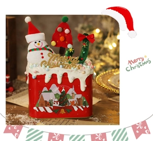 Vista dettagliata di una confezione regalo natalizia in latta rossa con decorazioni.