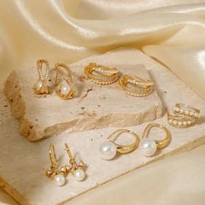 Élégant ensemble de boucles d'oreilles perles dorées et zircons sur soie et pierre