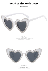 Detailed view of white heart-shaped sunglasses with double-layer rhinestone embellishments