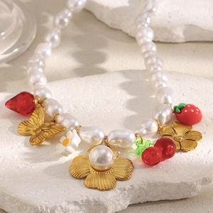 Detailed close-up of 18K gold plated necklace with baroque pearls and floral charms