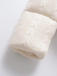 Close-up of white knit jacket cuffs showing detailed woven texture and folded design
