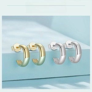 Detailed view of C-shaped S925 sterling silver earrings in gold and silver finishes