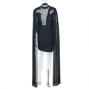 Detail of a slim black mini dress featuring a sheer floor-length tulle cape overlay