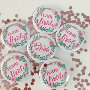 Close-up of Bride to be and Team Bride floral badges for bachelorette parties