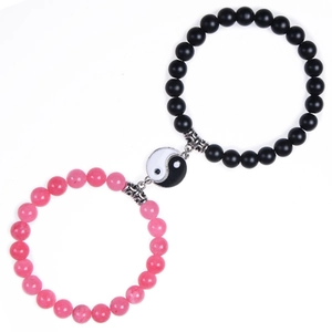 Detail of Yin Yang magnetic couple bracelets with black matte and pink textured beads