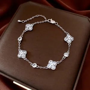 Silver flower bracelet with pavé cubic zirconia clover charms on a luxury jewelry box