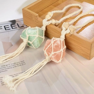 Handmade woven net pendant with natural citrine and fluorite crystals on wood tray