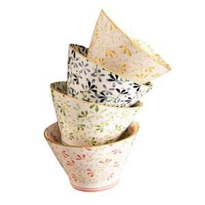 Stack of four ceramic rice bowls with colorful floral patterns and elegant gold trim