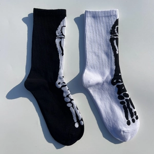 Détail de chaussettes mi-hautes en coton avec motifs de crânes en noir et blanc