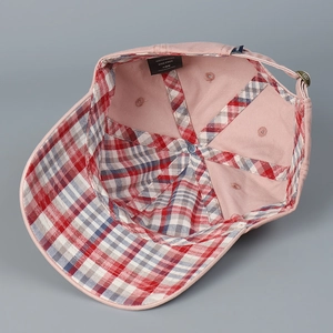 Detail of pink cotton baseball cap interior with plaid lining and 100% cotton wash label